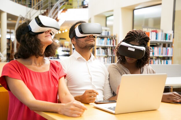 Equipo diverso de estudiantes adultos que usan tecnología VR para el trabajo.
