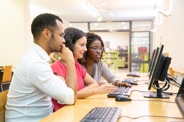 Equipo diverso de estudiantes adultos trabajando juntos.