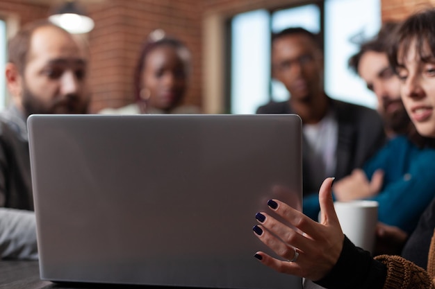 Equipo diverso que analiza las estadísticas de marketing utilizando una computadora portátil que trabaja en colaboración empresarial durante una reunión de negocios en la oficina de inicio. Empresarios multiétnicos intercambiando ideas para el proyecto de la empresa