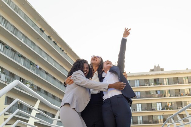 Equipo empresarial femenino unido celebrando el éxito