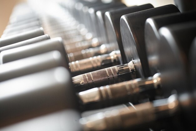 Equipo de entrenamiento con pesas en un moderno gimnasio interior. Imagen de primer plano de mancuernas en un soporte. Equipo de gimnasio.