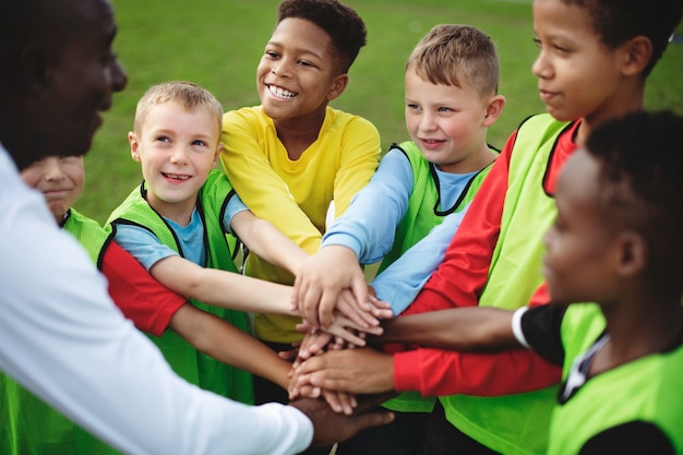 Equipo de fútbol junior apilando las manos antes de un partido