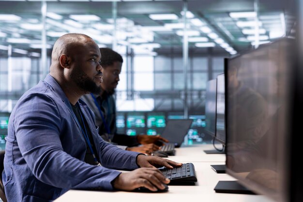 Equipo de ingenieros en el centro de datos usando computadoras para comprobar los servidores