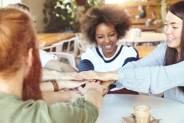 Foto gratuita equipo de jóvenes colegas que se reúnen en el café