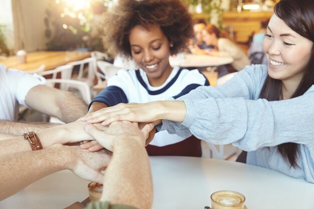 Equipo de jóvenes colegas que se reúnen en el café