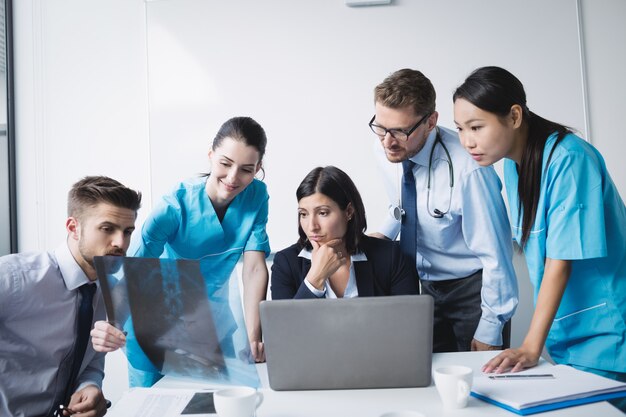 Equipo médico examinando un informe de rayos x.