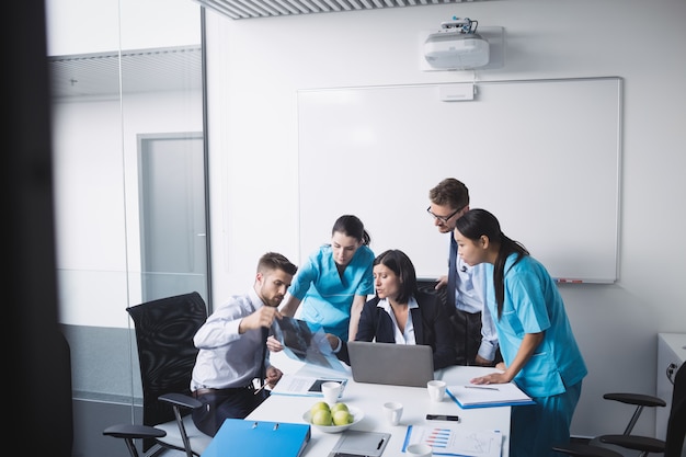 Foto gratuita equipo médico examinando un informe de rayos x.