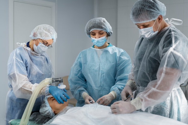 Equipo médico con el paciente en la sala de operaciones