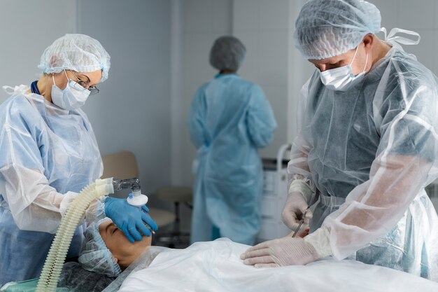 Equipo médico con el paciente en la sala de operaciones