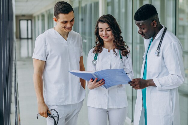 equipo de médicos especialistas jóvenes revisando documentos en el pasillo del hospital