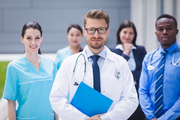 Equipo de médicos parados juntos en las instalaciones del hospital