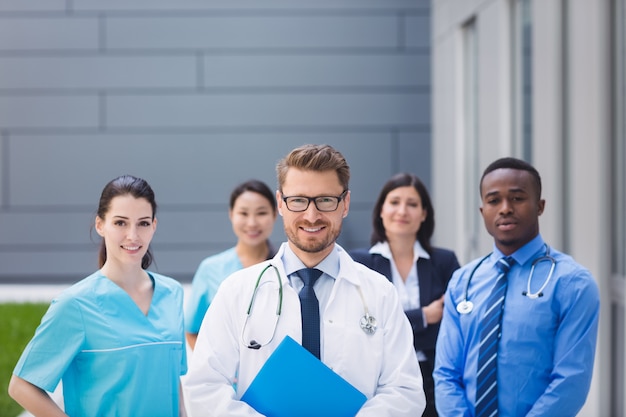 Equipo de médicos parados juntos en las instalaciones del hospital