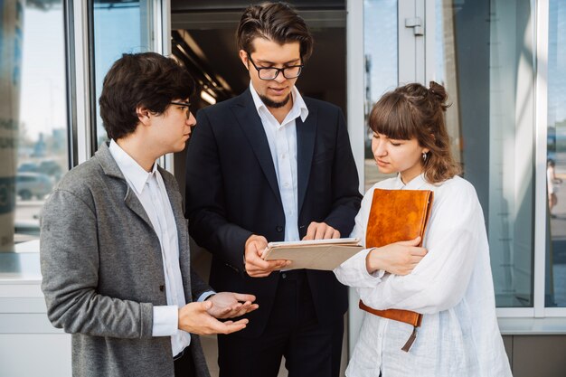 Equipo de negocios dos hombres y mujeres trabajando juntos afuera.