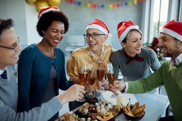 Equipo de negocios feliz brindando con champán en la fiesta de Navidad en la oficina