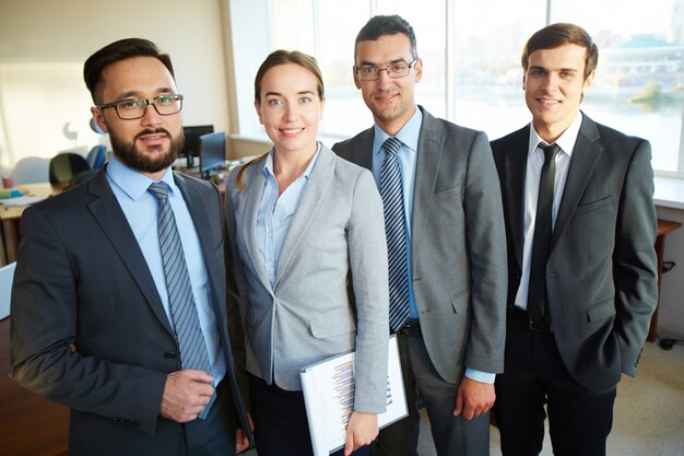 Equipo de negocios feliz de pie en una fila