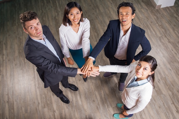 Equipo de negocios con las manos sonriendo juntos en el pabellón