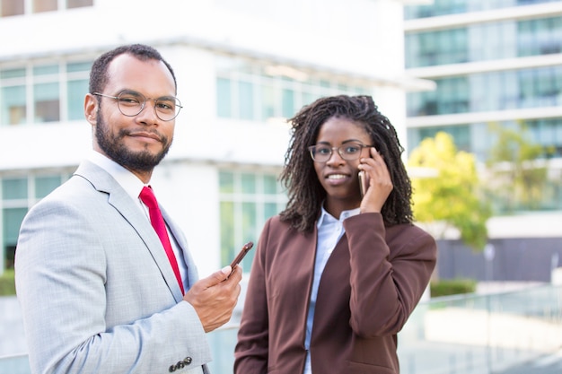 Equipo de negocios multiétnico que usa teléfonos inteligentes