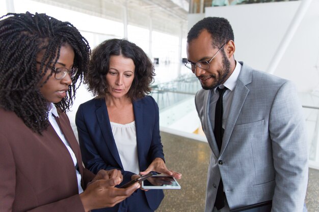 Equipo de negocios que consulta internet en dispositivos digitales juntos