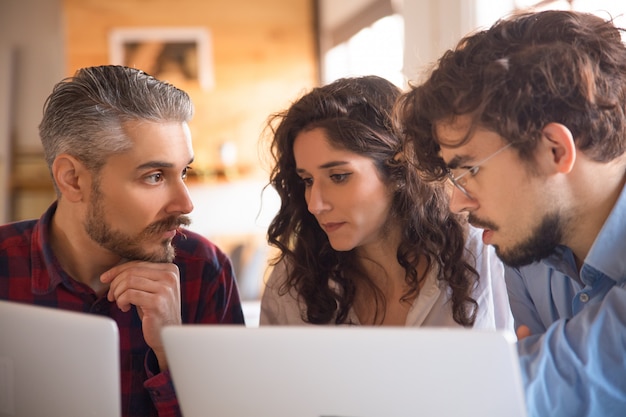 Equipo de negocios que genera ideas para proyectos, utilizando computadoras portátiles