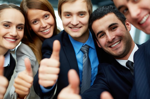 Equipo de negocios sonriente con pulgares levantados