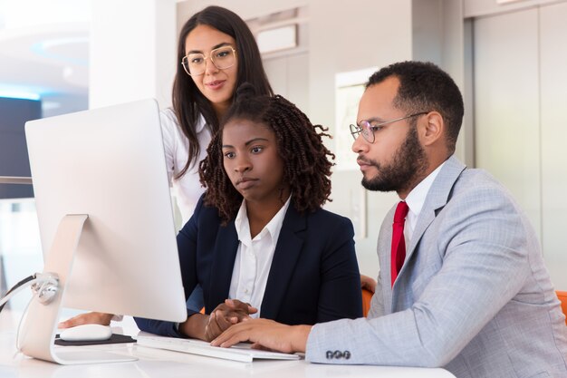 Equipo de negocios viendo la presentación del proyecto en el escritorio juntos