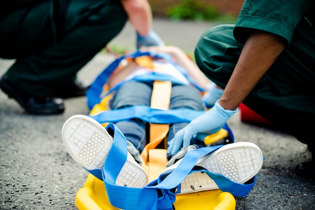 Foto gratuita equipo paramédico rescatando a un joven paciente crítico