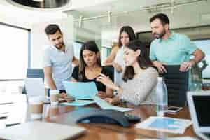 Foto gratuita equipo de profesionales de negocios discutiendo sobre el archivo en el escritorio en la oficina creativa durante la reunión