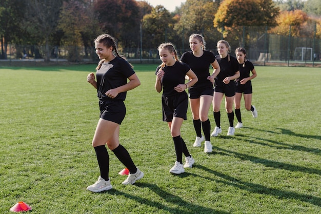 Equipo de rugby femenino corriendo por conos