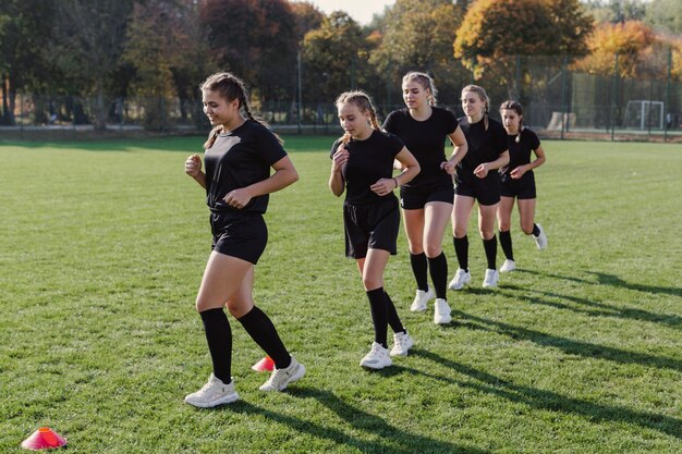 Equipo de rugby femenino corriendo por conos