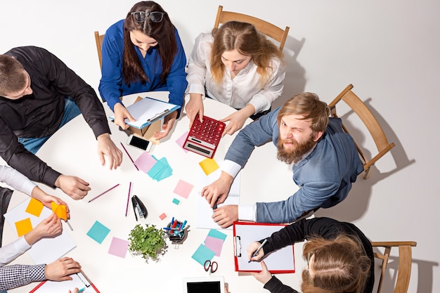 Equipo sentado detrás del escritorio, revisando informes, hablando.