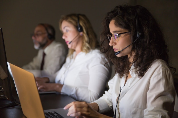 Equipo de teletrabajadores que trabajan en oficinas oscuras