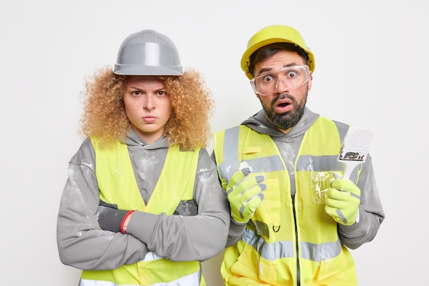 El equipo de trabajadores industriales de mujer y hombre vestidos de uniforme recibe instrucciones del empleador para mantener el equipo de construcción.