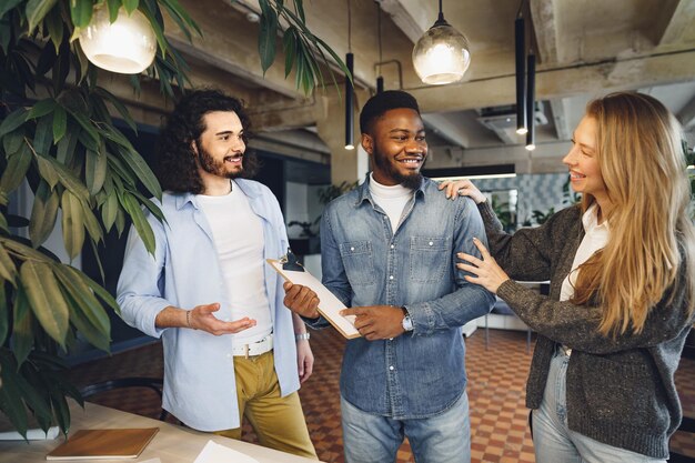 Equipo de trabajo de oficina saludando a su nuevo empleado masculino afroamericano