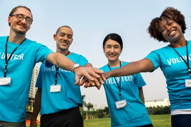 Equipo de voluntarios apilando las manos