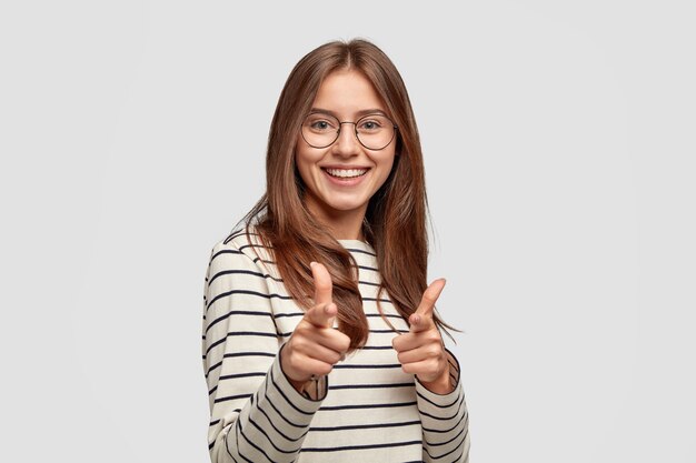 ¡Eres elegido! Alegre mujer europea sonriente hace gesto de pistola de dedo