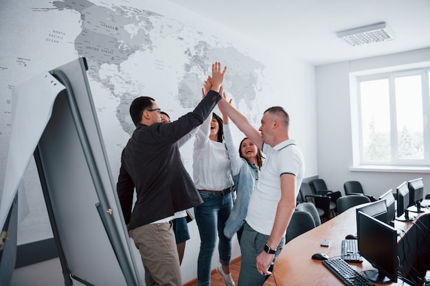 Eres increíble, felicitaciones. Empresarios y gerente trabajando en su nuevo proyecto en el aula