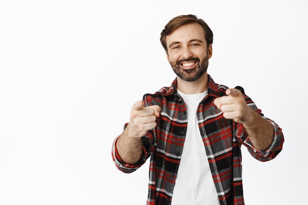 Eres tú, enhorabuena. Un tipo barbudo sonriente señalando con el dedo a la cámara te alaba por elegir candidato invitando a la gente de pie sobre fondo blanco.