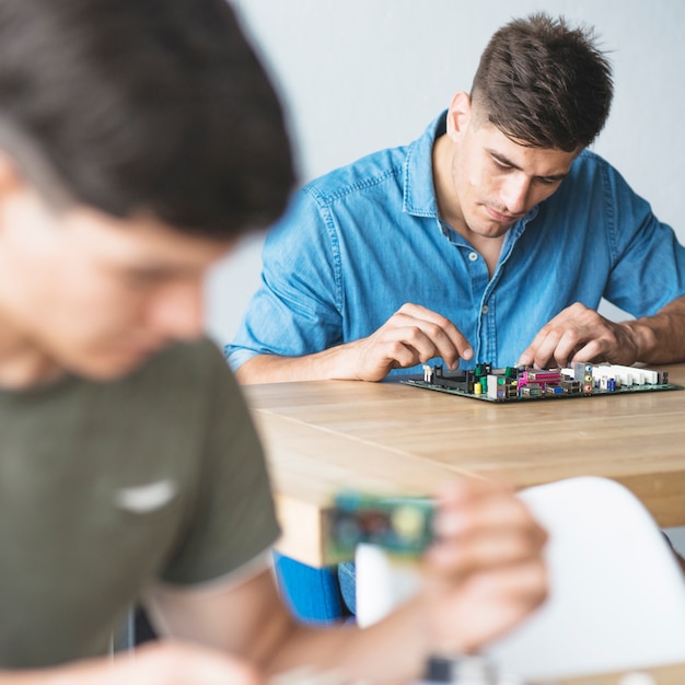 Foto gratuita es estudiantes arreglando los equipos de hardware