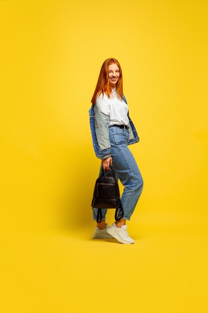 Es más fácil ser seguidor. Necesita ropa mínima para ir. Retrato de mujer caucásica sobre fondo amarillo. Modelo de pelo rojo mujer hermosa. Concepto de emociones humanas, expresión facial, ventas, publicidad.