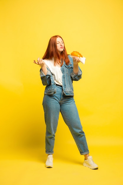 Es más fácil ser seguidor. No es necesario que tomes fotos con comida. Mujer caucásica sobre fondo amarillo. Modelo de pelo rojo mujer hermosa. Concepto de emociones humanas, expresión facial, ventas, publicidad.