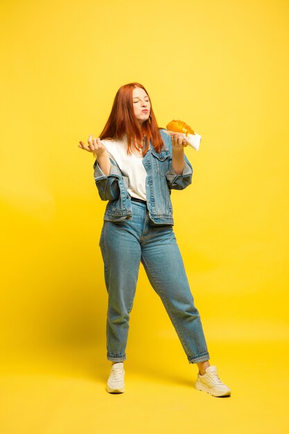 Es más fácil ser seguidor. No es necesario que tomes fotos con comida. Mujer caucásica sobre fondo amarillo. Modelo de pelo rojo mujer hermosa. Concepto de emociones humanas, expresión facial, ventas, publicidad.