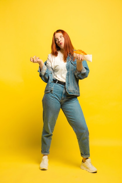 Es más fácil ser seguidor. No es necesario que tomes fotos con comida. Mujer caucásica sobre fondo amarillo. Modelo de pelo rojo mujer hermosa. Concepto de emociones humanas, expresión facial, ventas, publicidad.