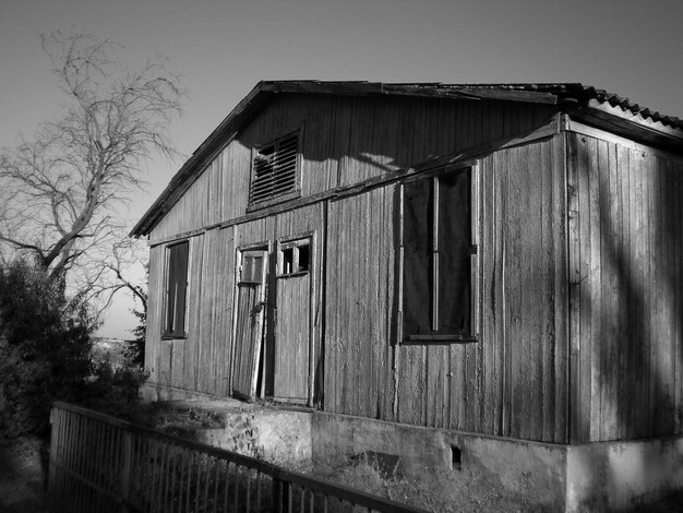 Escala de grises de un antiguo granero de madera bajo la luz del sol durante el día