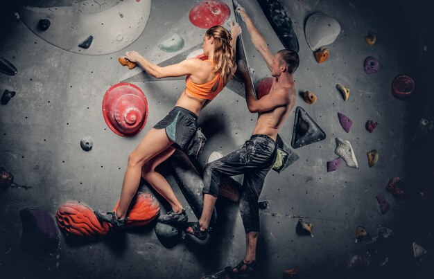 Escalada deportiva masculina y femenina en un muro de escalada.