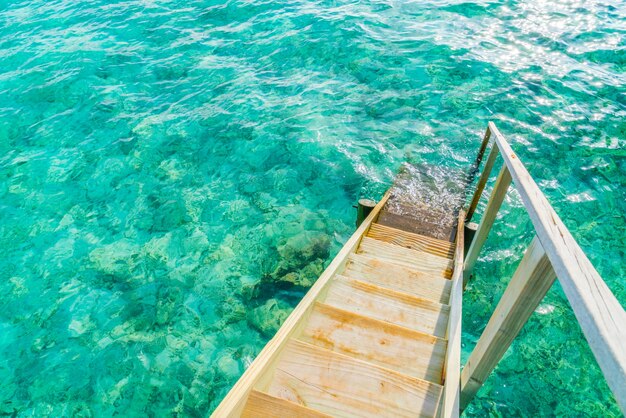 Escalera de madera en el mar de la isla tropical de Maldivas.