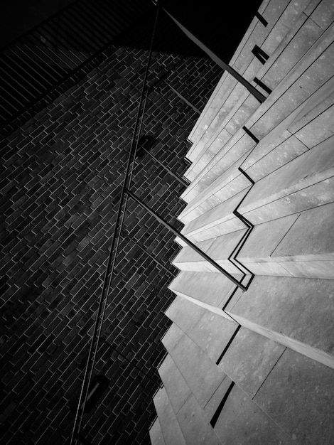 Escaleras con barandilla y pared de ladrillo.