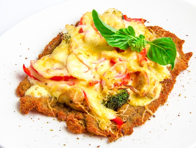 Escalope crujiente de ternera con queso, tomates, pimientos, brócoli y champiñones