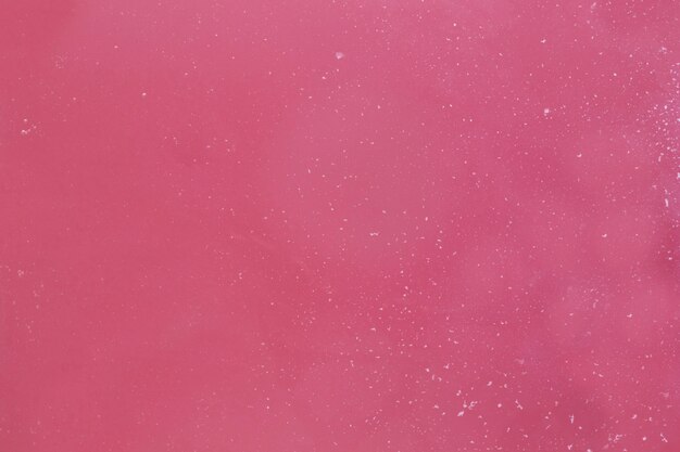 Escamas de espuma en agua rosa