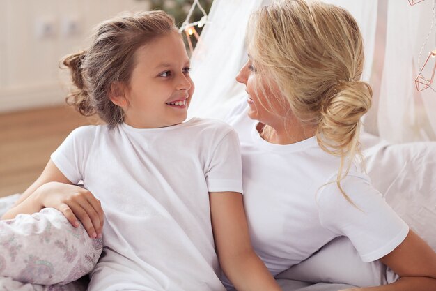 Escena familiar. Feliz madre e hija en una cama