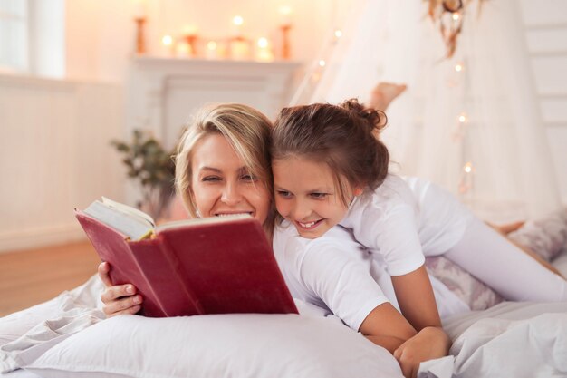 Escena familiar. Feliz madre e hija en una cama